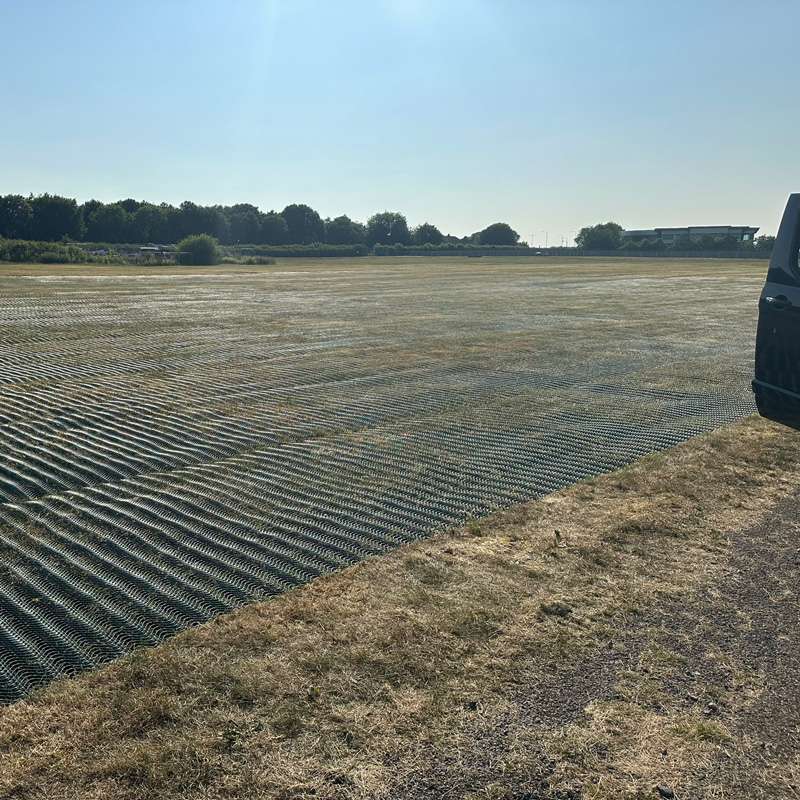 Angled shot of green mesh reinforcement fully integrated with the grass surface under early morning light.