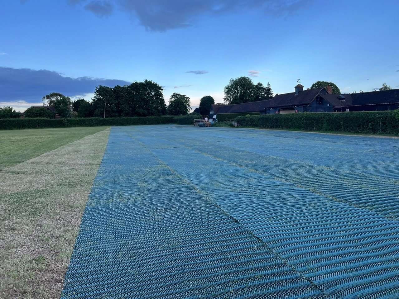 Heavy grass reinforcement mesh installed across a farm overflow parking field