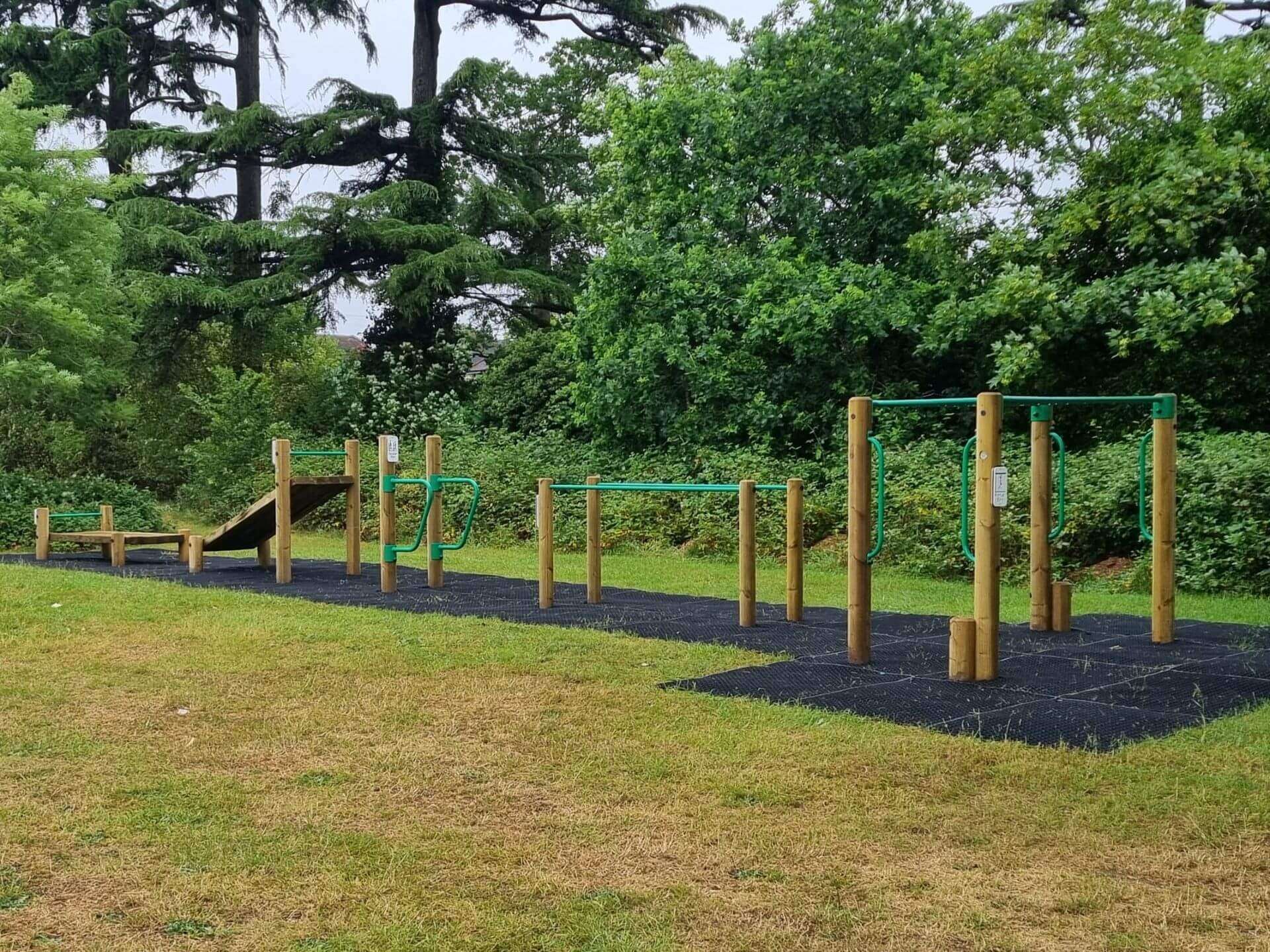 Outdoor fitness trail with playground safety grass mats installed
